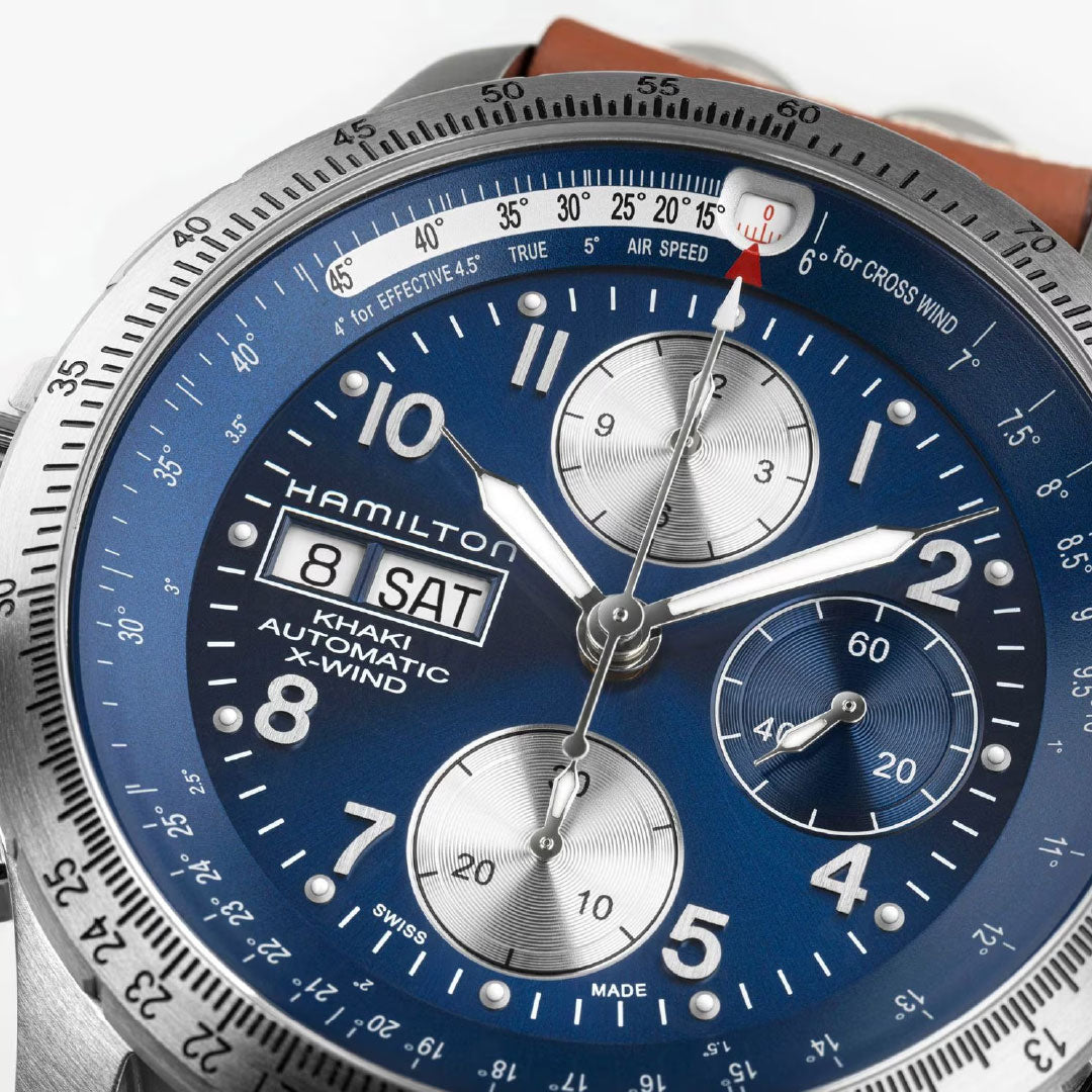 Close-up of the Hamilton Watch Khaki Aviation X-Wind Auto Chrono 44mm with a blue dial, three subdials, day-date display, silver hour markers, rotating bezel, and brown leather strap—an outstanding automatic chronograph.