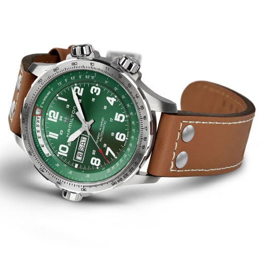 The Hamilton Khaki Aviation X-Wind Day Date Auto 45mm by Hamilton Watch features a green dial with white numerals, chronograph functions, a brown leather strap with white stitching and rivets, and is powered by the robust H-30 movement.