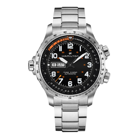 The Hamilton Khaki Aviation X-Wind Day Date Auto 45mm Watch by Hamilton Watch features a silver design with a black dial, showcasing SuperLumiNova numerals and white hands. It includes an automatic Day Date display on the right side and is complemented by a stainless steel bracelet. The bezel has additional markings, while the three side buttons are enhanced by Khaki X-Wind design elements.