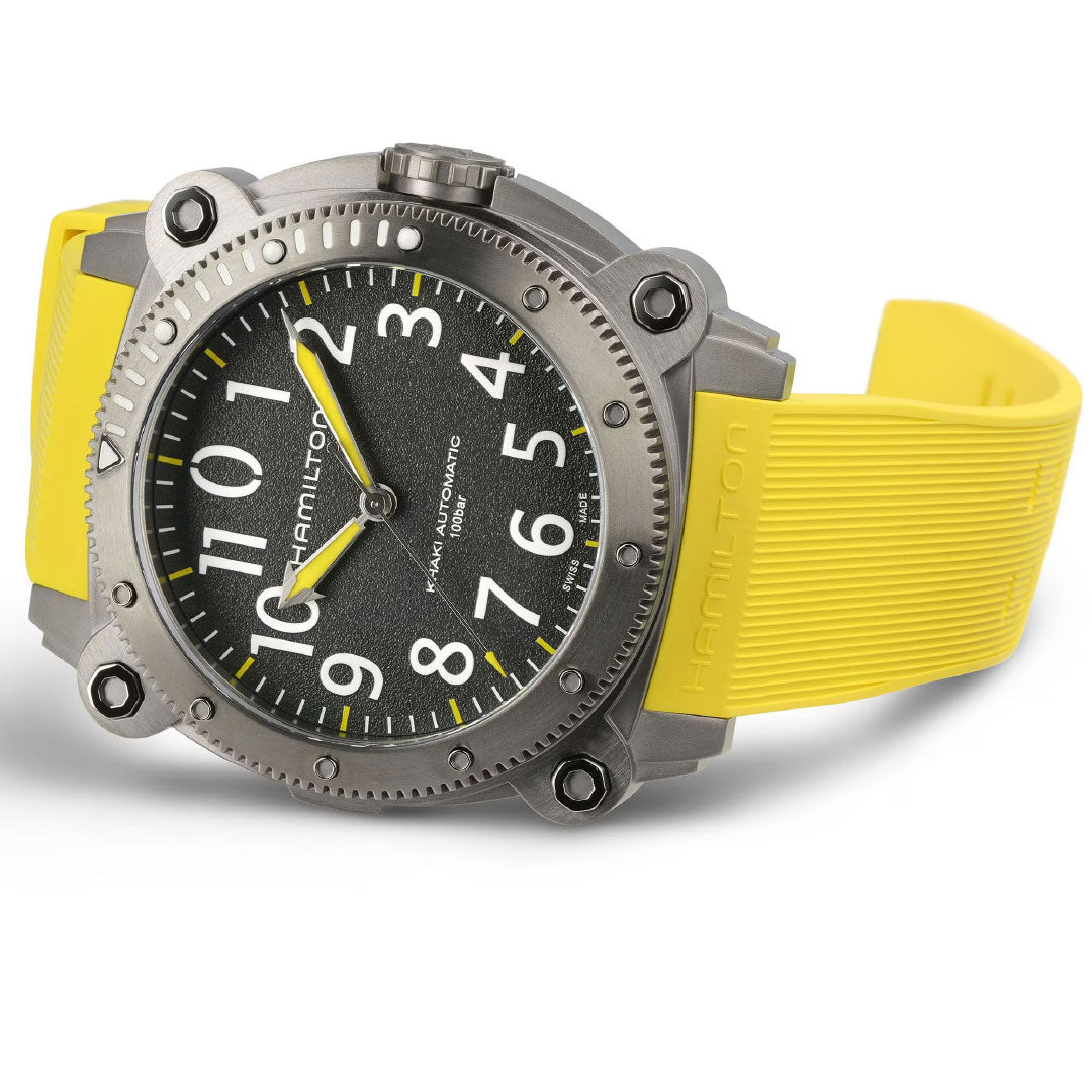 The Hamilton Khaki Navy BeLow Zero Auto Titanium 46mm Watch by Hamilton Watch features a large round metal case, black textured dial with white numerals, and a bright yellow rubber strap, displayed at an angle on a white background.