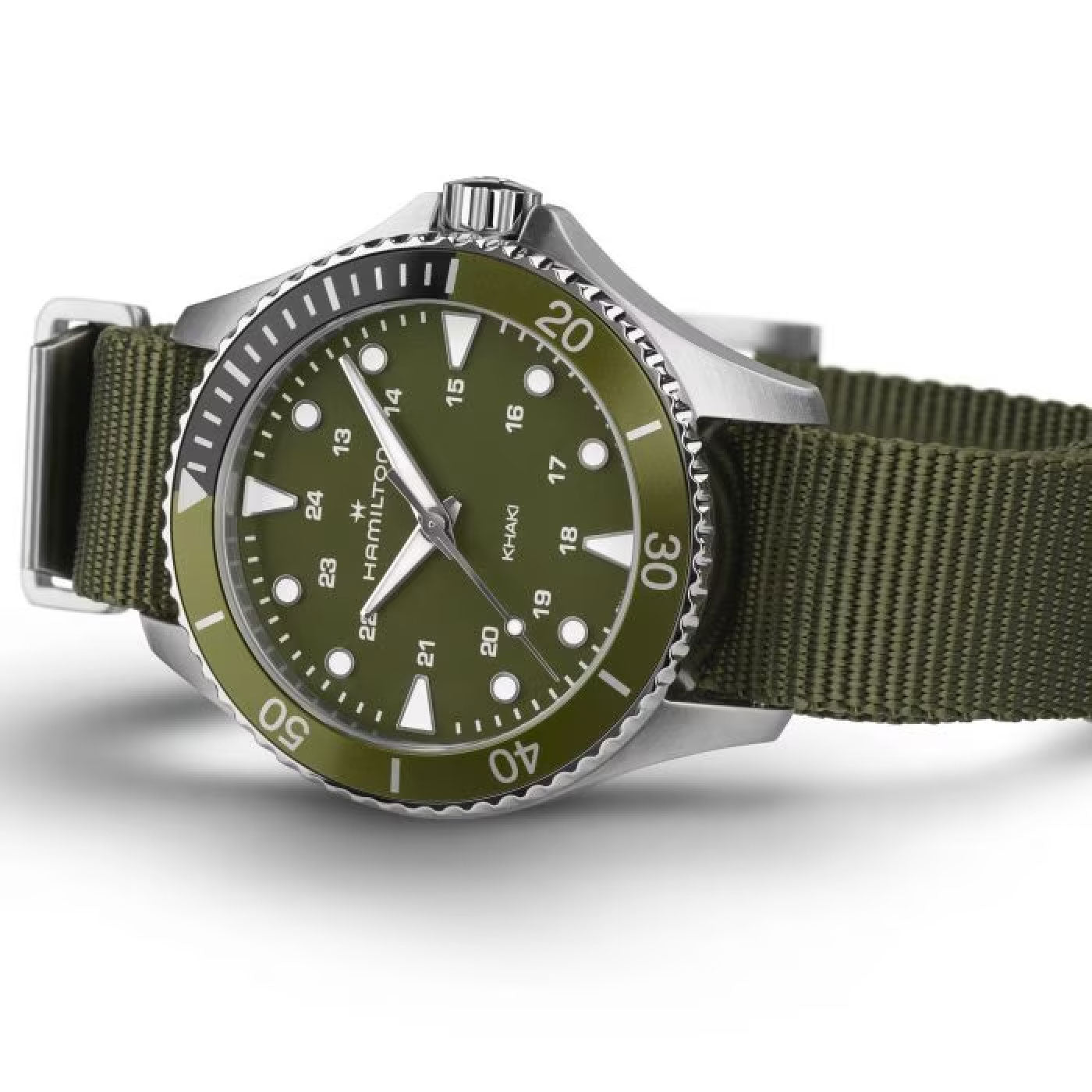 A Hamilton Khaki Navy Scuba Quartz 37mm watch from Hamilton Watch is showcased at an angle, featuring a vibrant green dial with white numerals and indices, complemented by a stainless steel case and a striking unidirectional bezel.