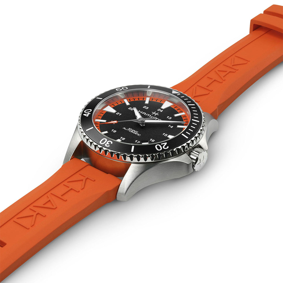 The Hamilton Khaki Navy Scuba Auto 40mm Watch by Hamilton Watch features a black dial, black rotating bezel, silver crown, and a tangerine orange rubber strap engraved "KHAN.