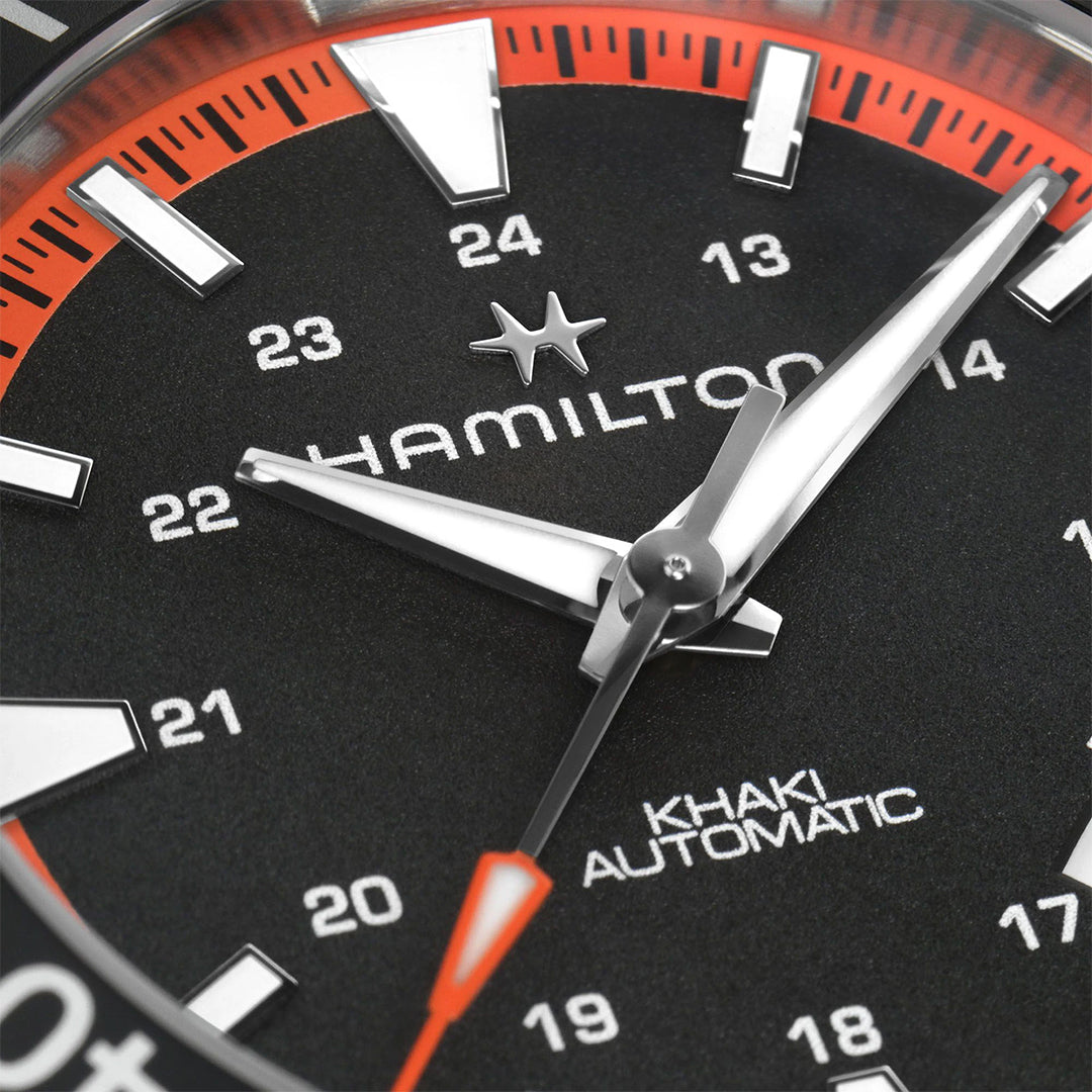 Close-up of the Hamilton Khaki Navy Scuba Auto 40mm by Hamilton Watch, featuring a black dial, bold white numerals, red and white accents, and a vibrant tangerine orange rubber strap.