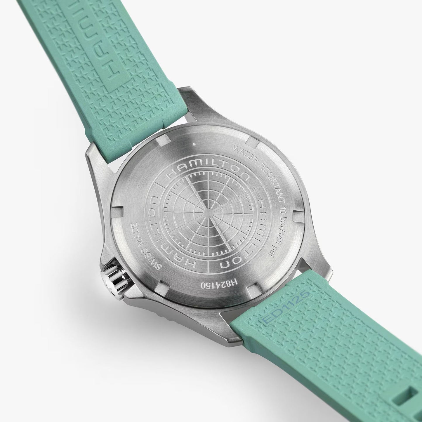Close-up of the brushed metal back of the Hamilton Watch Khaki Navy Scuba Auto 40mm, showing engraved branding, model details, and aqua blue textured silicone straps.