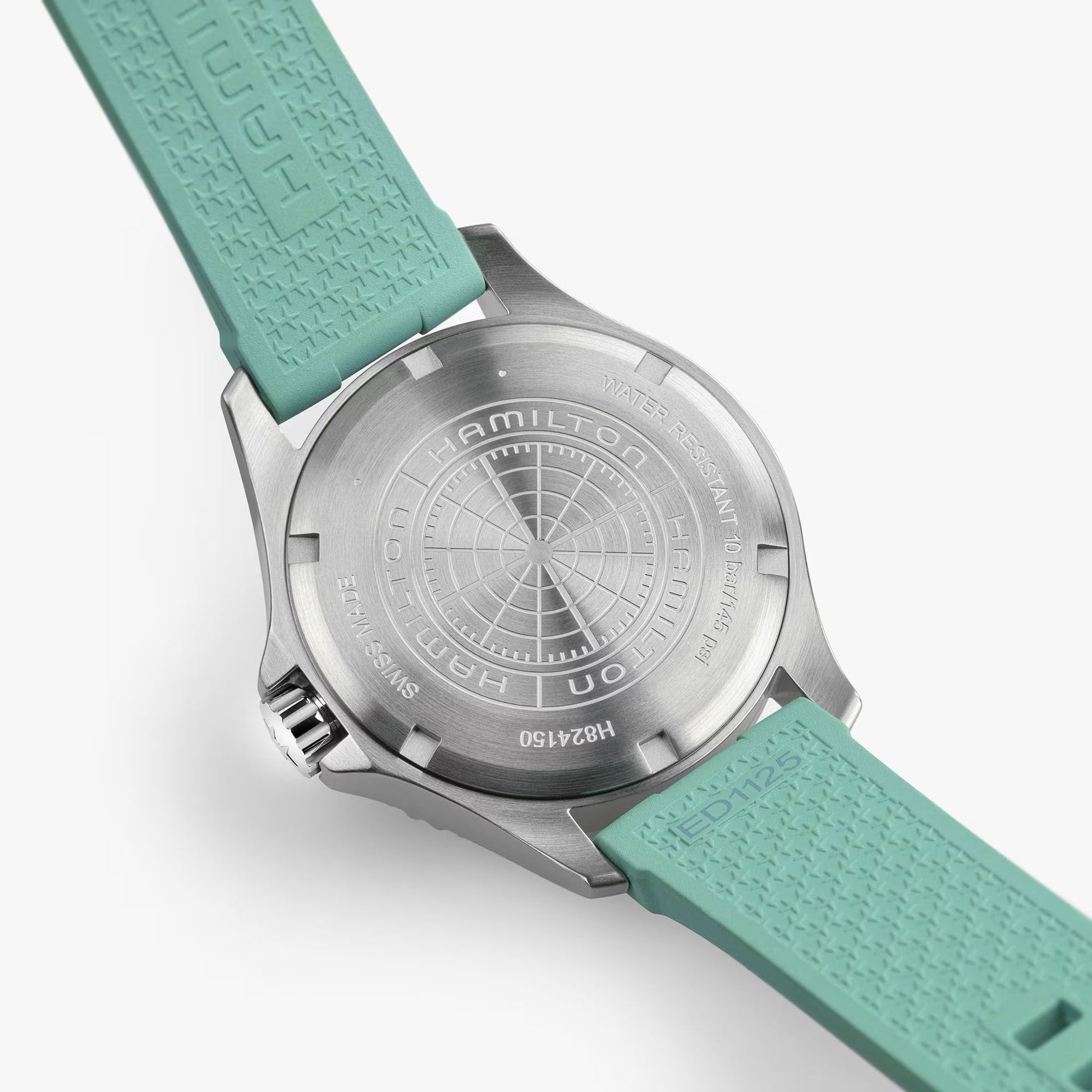 Close-up of the brushed metal back of the Hamilton Watch Khaki Navy Scuba Auto 40mm, showing engraved branding, model details, and aqua blue textured silicone straps.