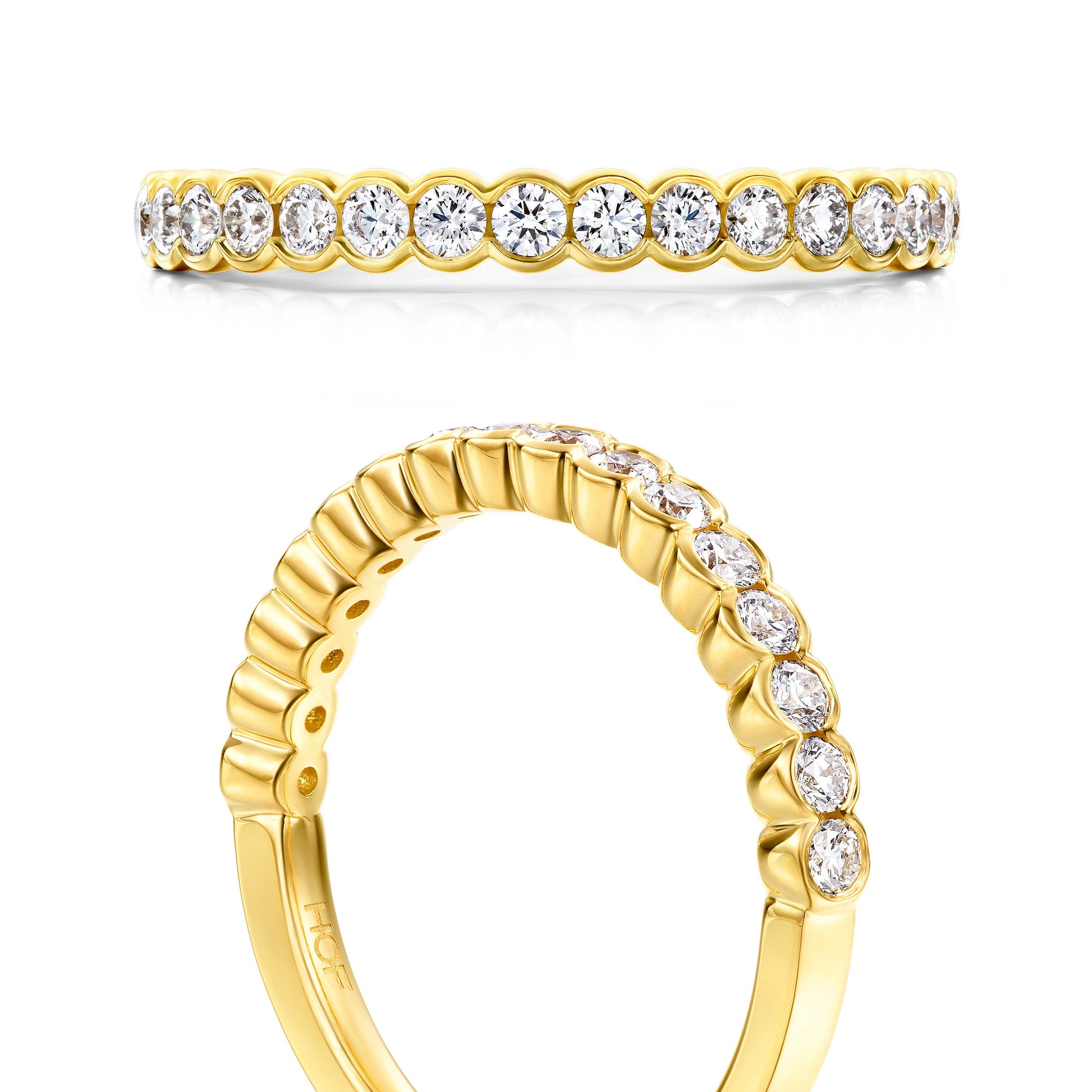 The Hearts On Fire Isabelle 18K Yellow Gold Bezel Round Brilliant Diamond Anniversary Ring boasts a row of round, sparkling diamonds. The top view reveals the complete circle of stones, while the angled side view emphasizes the intricate setting and band detail, creating a beautifully classic allure from Hearts on Fire.