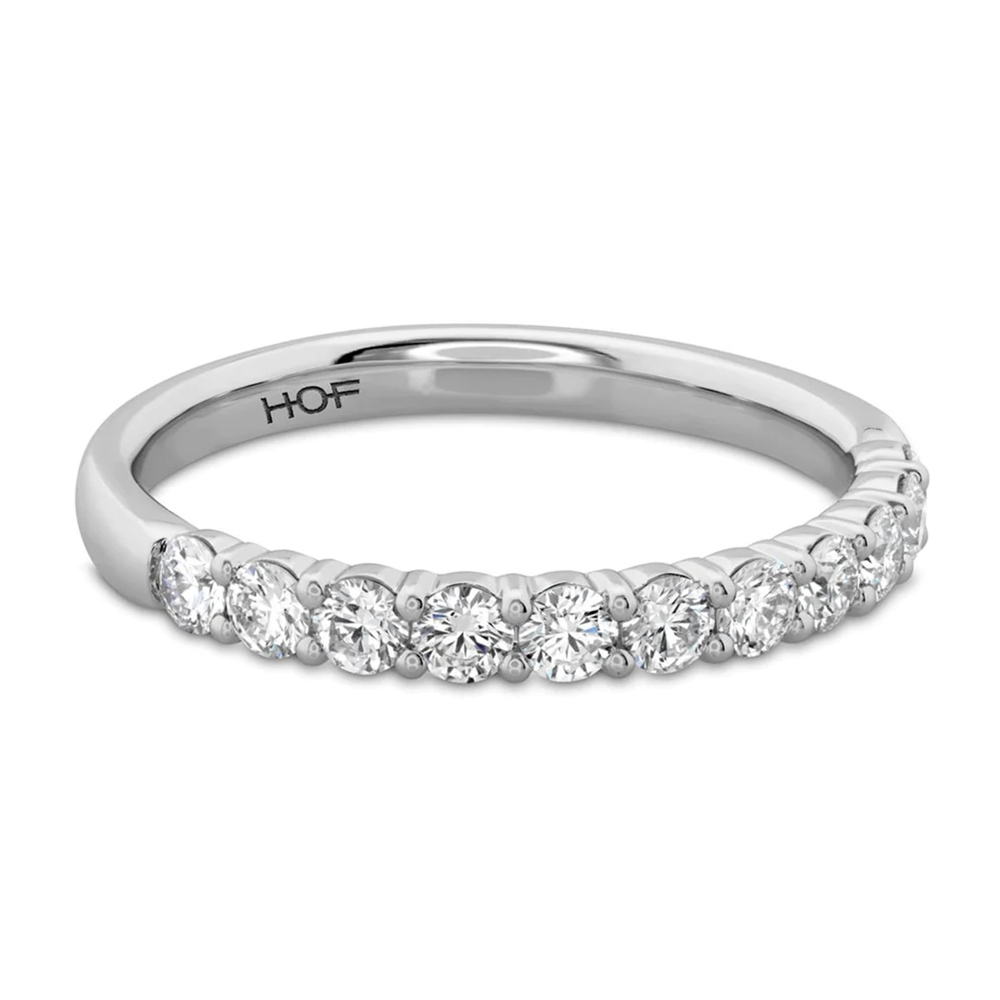 The Hearts On Fire Signature 18K White Gold Round Brilliant Diamond Anniversary Ring by Hearts on Fire is crafted with a row of round, sparkling diamonds. The design is simple yet elegant, prominently showcasing the exquisite diamonds.