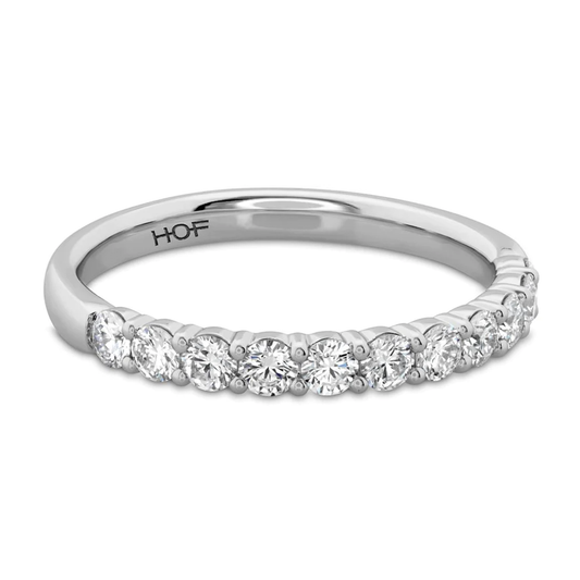 The Hearts On Fire Signature 18K White Gold Round Brilliant Diamond Anniversary Ring by Hearts on Fire is crafted with a row of round, sparkling diamonds. The design is simple yet elegant, prominently showcasing the exquisite diamonds.