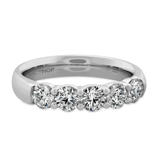 The Hearts On Fire Signature 18K White Gold Round Brilliant Diamond Anniversary Ring by Hearts on Fire is a silver band adorned with five round-cut diamonds set in a row.