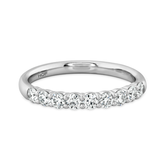 This Hearts On Fire Signature 18K White Gold Round Brilliant Diamond Anniversary Ring showcases a row of sparkling round diamonds along the top half and is complemented by a smooth, polished band crafted from 18 Karat White Gold.