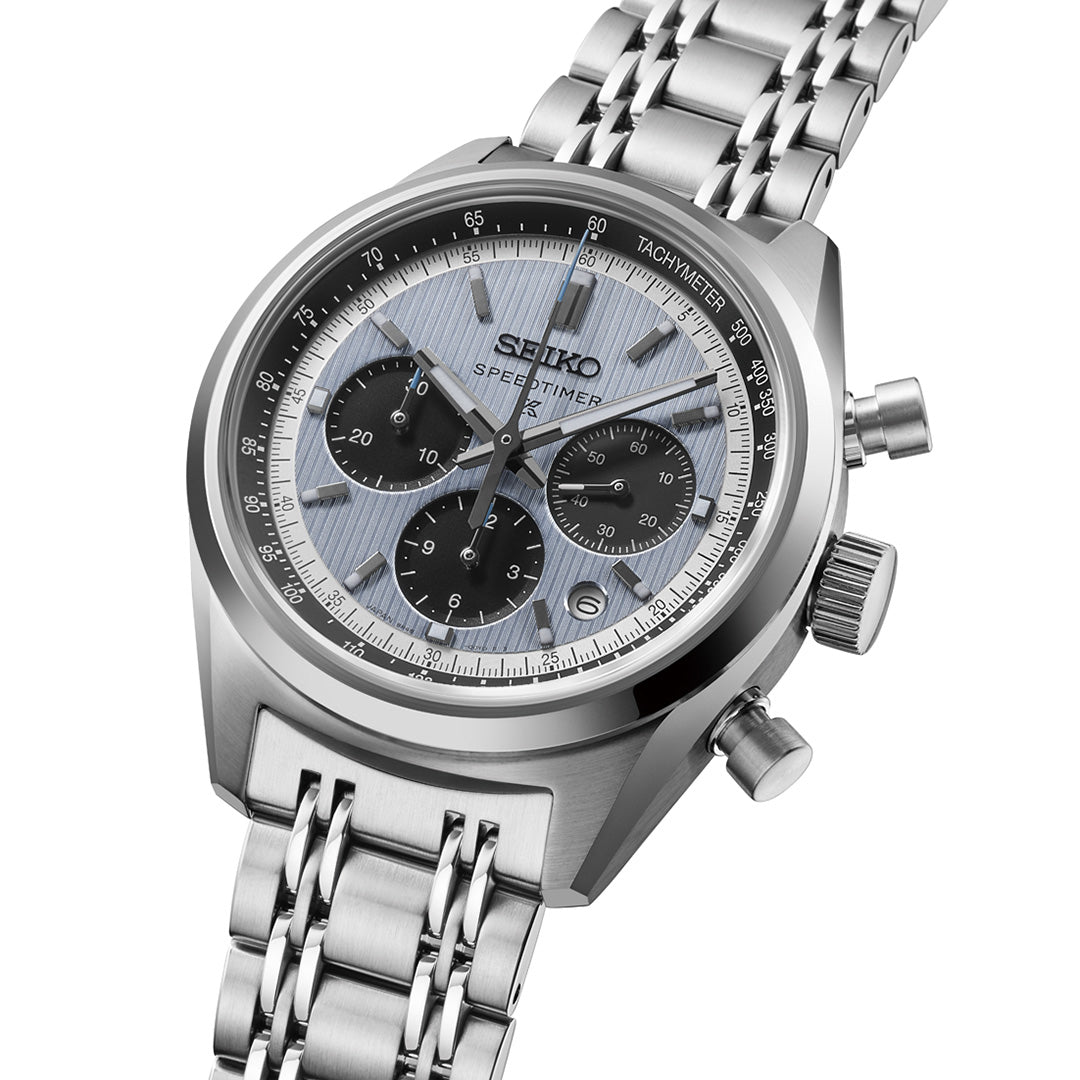 The Seiko Prospex Speedtimer Automatic With Manual Winding 42mm Watch by Seiko features a stainless steel band, a silver case, and a blue striped dial with three black subdials that highlight its precise chronograph function. The watch is positioned at an angle on a white background.