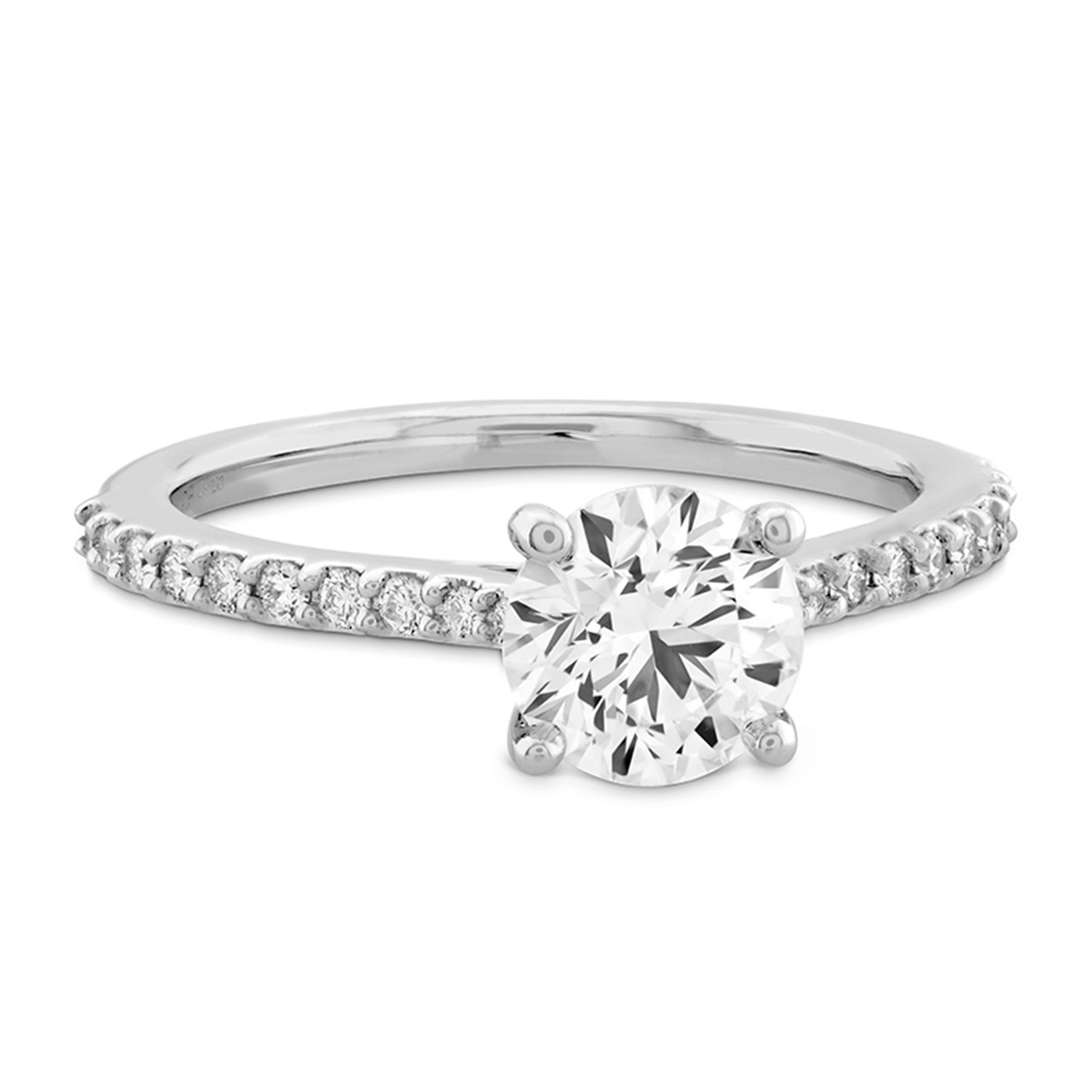 The Hearts On Fire Camilla 18K White Gold Semi Mount Solitaire Engagement Ring features a prominent round diamond centerpiece, complemented by smaller diamonds on its delicate 18K white gold band.