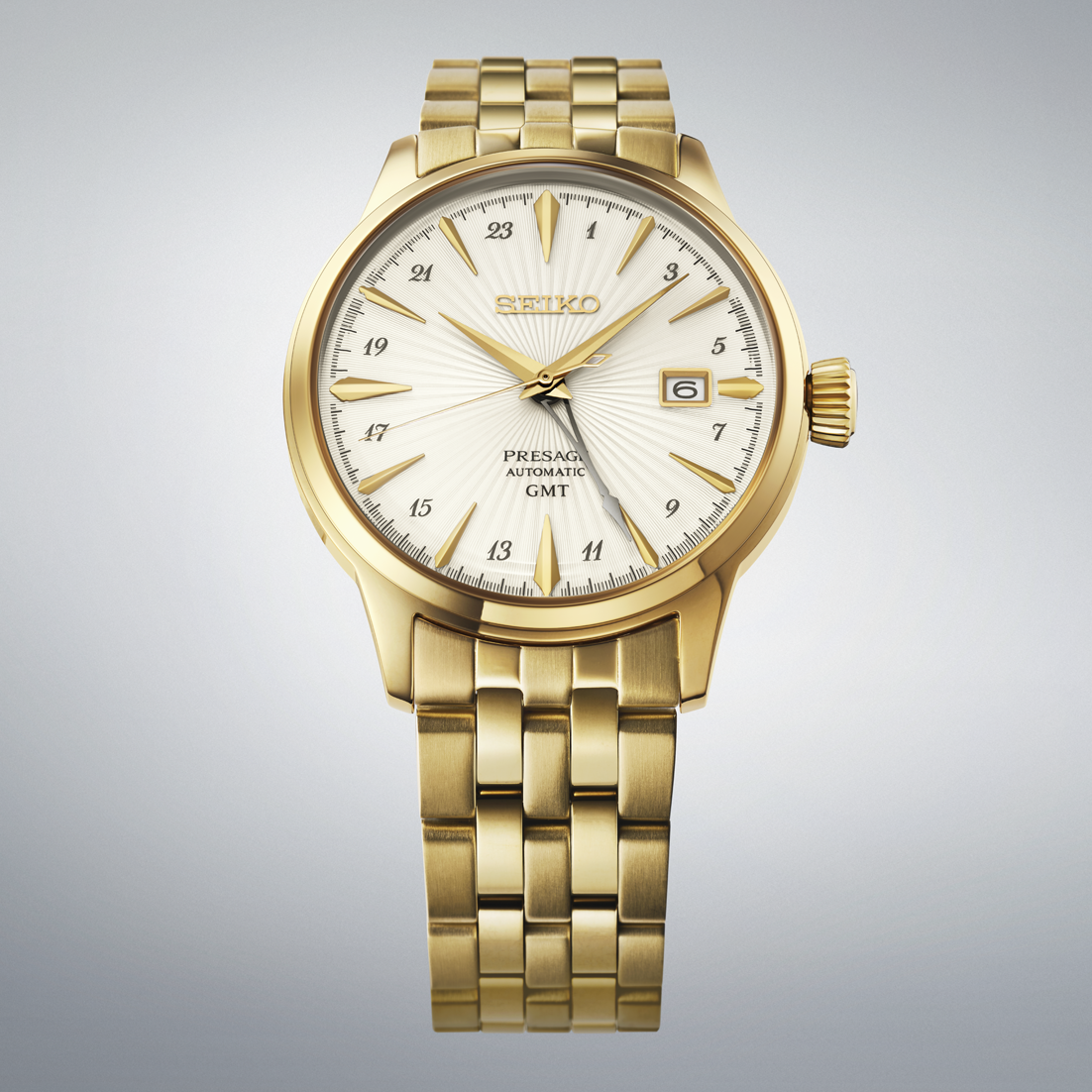 Gold-tone Seiko Presage Cocktail Time GMT Automatic With Manual Winding 40.5mm Watch featuring a sunburst white dial, gold hour markers, and a matching gold-tone metal link bracelet.