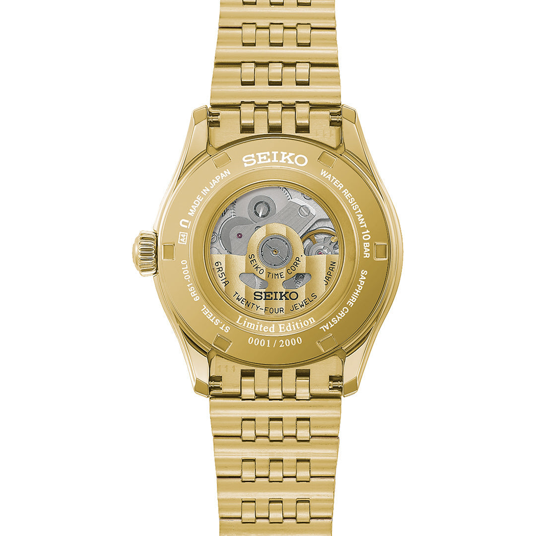 The Seiko Presage Classic Series Tradman’s Bonsai Automatic 38mm Watch, a limited edition of 2,000 pieces, features a gold finish with a transparent case back that showcases its automatic movement and is engraved with “Limited Edition” and “0001/2000.” Attached to a matching gold link bracelet, this distinctive Seiko timepiece exemplifies refined craftsmanship and exclusive style.
