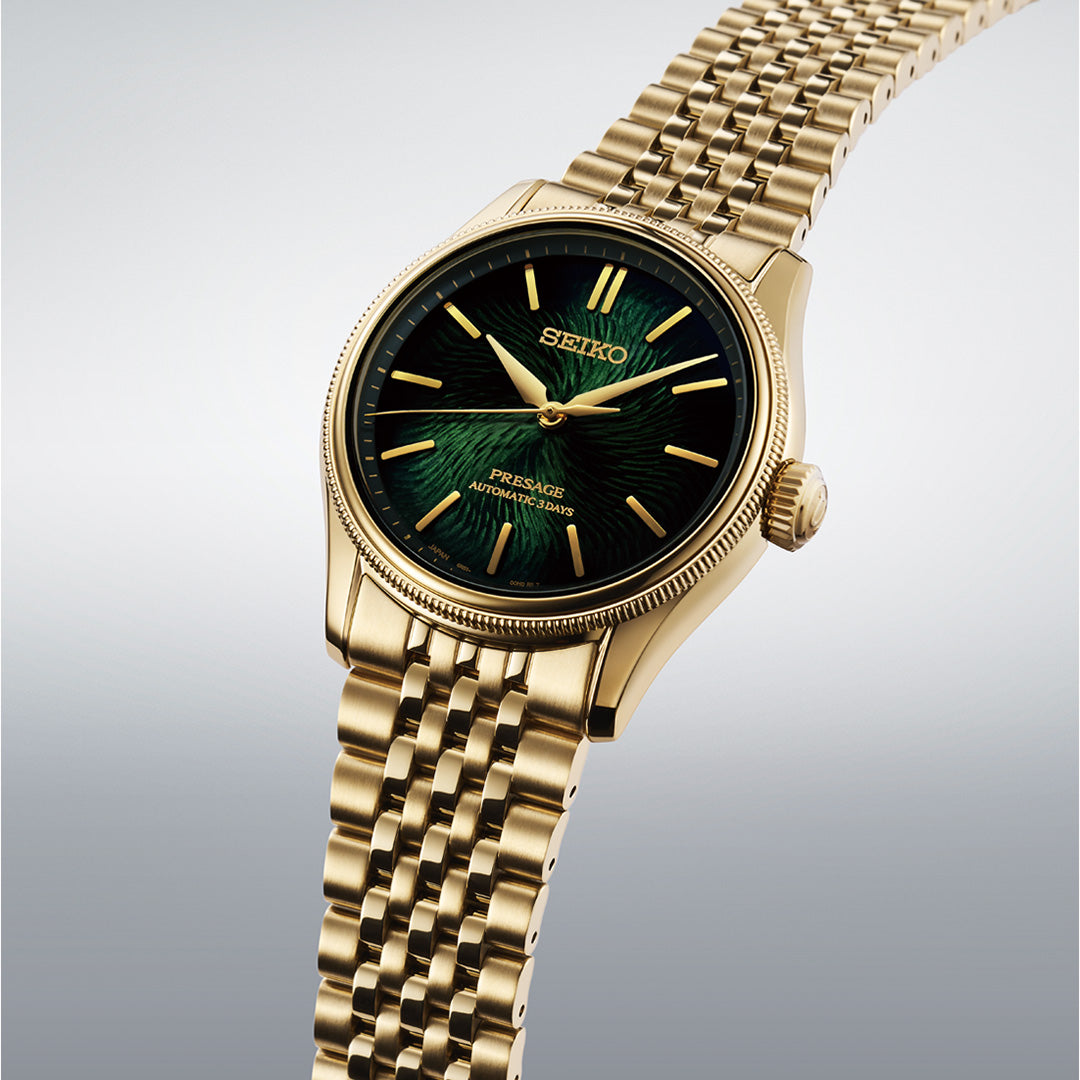 A Seiko Presage Classic Series Tradman’s Bonsai Automatic 38mm Watch, Limited Edition of 2,000 pieces, featuring a green textured dial with gold hour markers and a metal link bracelet, is displayed against a light gradient background. This refined Seiko wristwatch combines elegance and precision, making it an exceptional choice for discerning enthusiasts.