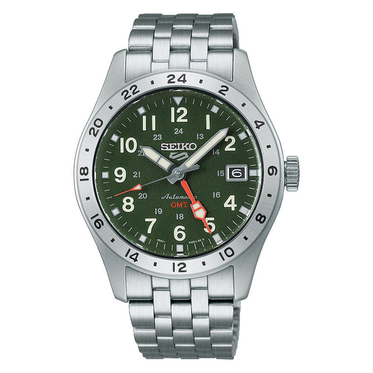 The Seiko 5 Sports Field Series GMT Automatic 39.3mm Watch by Seiko features a green dial with silver hour markers, a red GMT hand, and a stainless steel bracelet. This automatic timepiece is equipped with a bezel marked with 24-hour numerals and has a date window located at the 3 o’clock position.