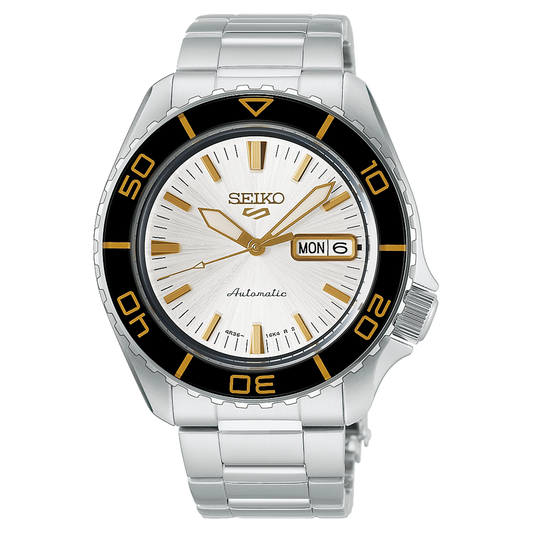Seiko 5 Sports SKX Series Automatic 42.5mm Watch with a silver link bracelet, a textured white dial with gold indices, and a black and gold rotating bezel featuring a day and date display at the three o’clock position.