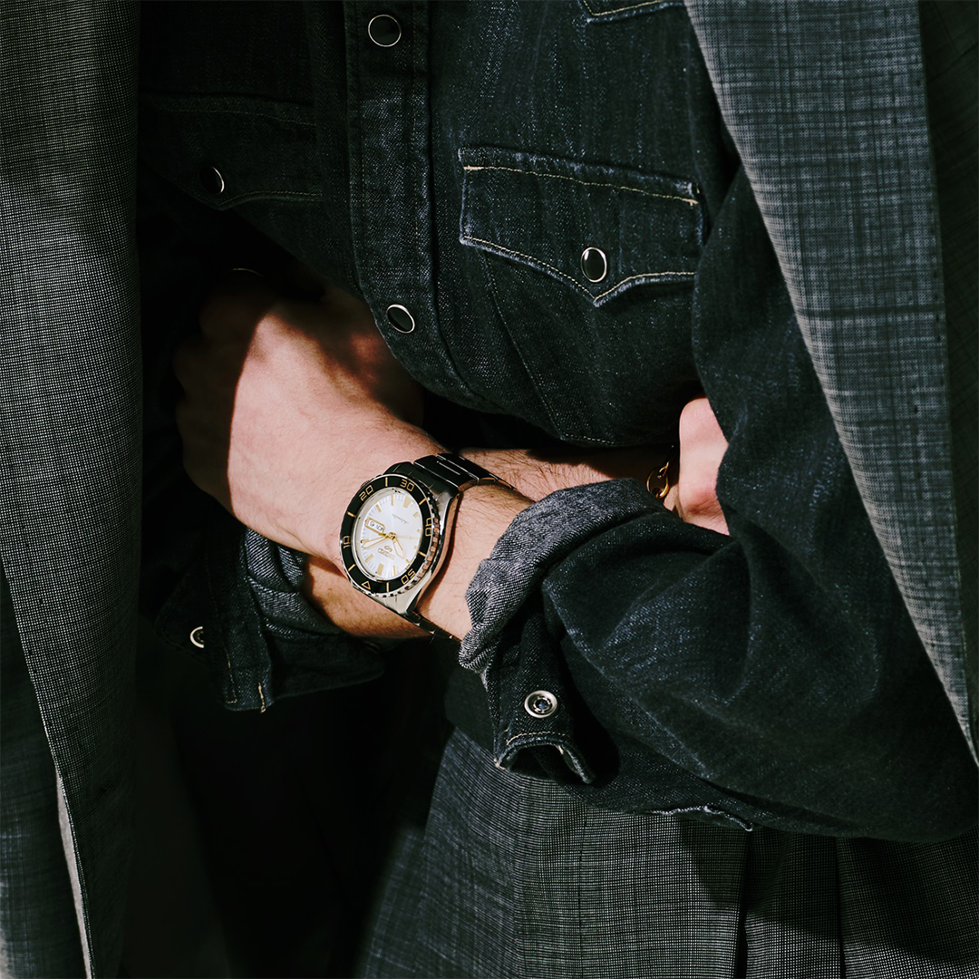 A silver Seiko 5 Sports SKX Series Automatic 42.5mm Watch with a white dial and black rotating bezel worn on a wrist.