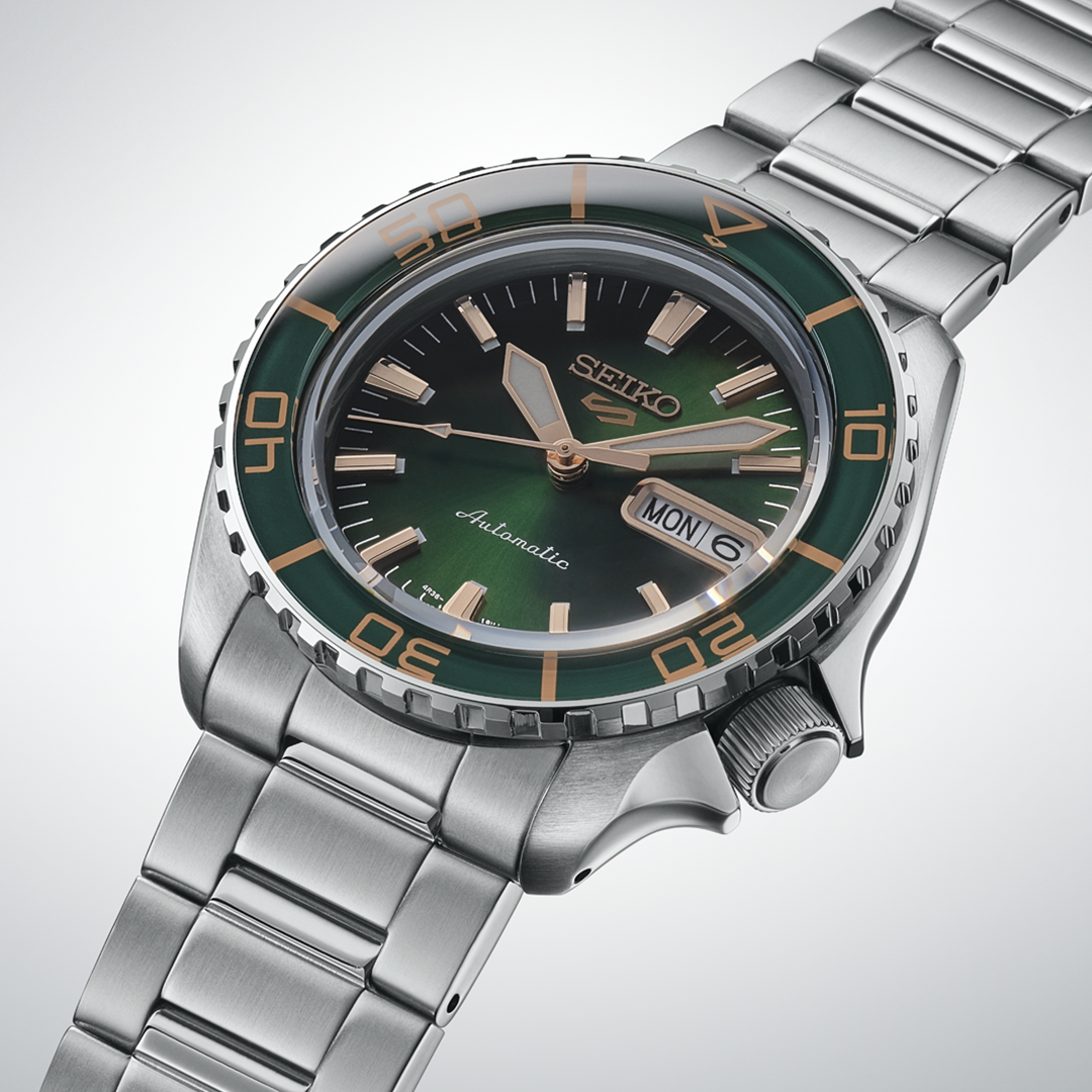 Seiko 5 Sports SKX Series Automatic 42.5mm Watch with a green sunray dial, gold-toned indices, a rotating bezel with green and gold accents, and a stainless steel link bracelet.