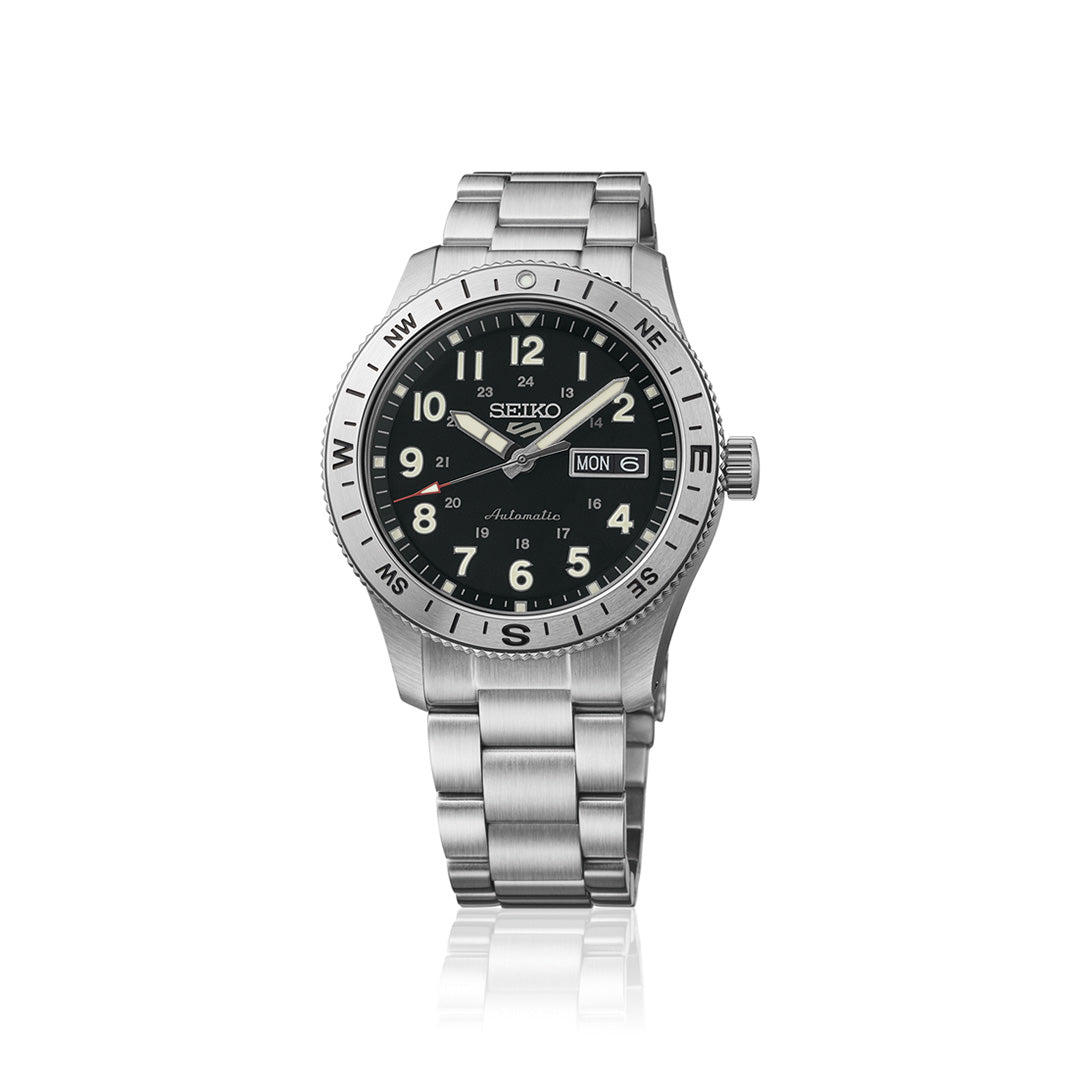 The Seiko 5 Sports Field Series Automatic 41mm Watch from Seiko features a silver-tone stainless steel metal bracelet, a black dial with white Arabic numerals, and compass markings on the bezel. LumiBrite-coated hands and markers enhance low-light visibility, while day and date displays add extra functionality.