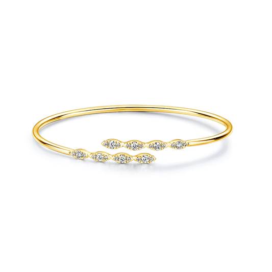 The Hearts On Fire Aerial 18K Yellow Gold Marquise Flexi Bangle is elegantly designed with an open structure, boasting two rows of small, sparkling gemstones arranged in a marquise pattern at the open ends. Its surface is smooth and shiny, subtly reflecting light.