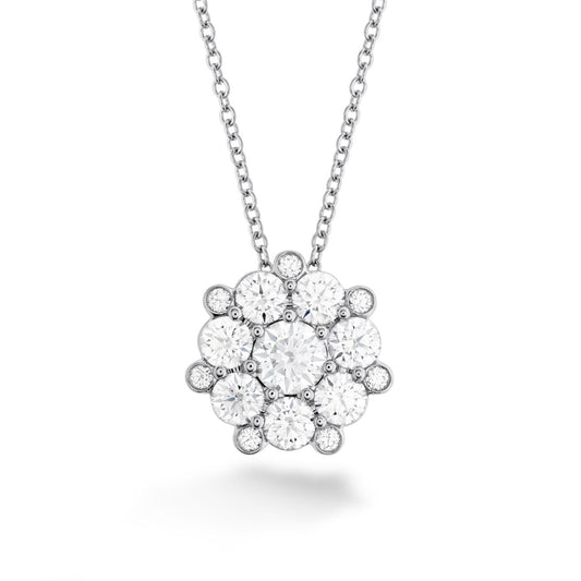The "Hearts On Fire Beloved 18K White Gold Diamond Cluster Pendant" by Hearts on Fire features a cluster of sparkling diamonds arranged in a floral pattern on an exquisite 18 Karat White Gold pendant. Its fine, delicate chain beautifully complements the brilliant design, all set against a plain white background that highlights its elegance and sophistication.