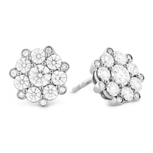 A pair of Hearts On Fire Beloved 18K Diamond Earrings, crafted by Hearts on Fire, showcases a floral cluster design with precision-cut central diamonds encircled by smaller diamonds, all elegantly set in lustrous 18 karat white gold.