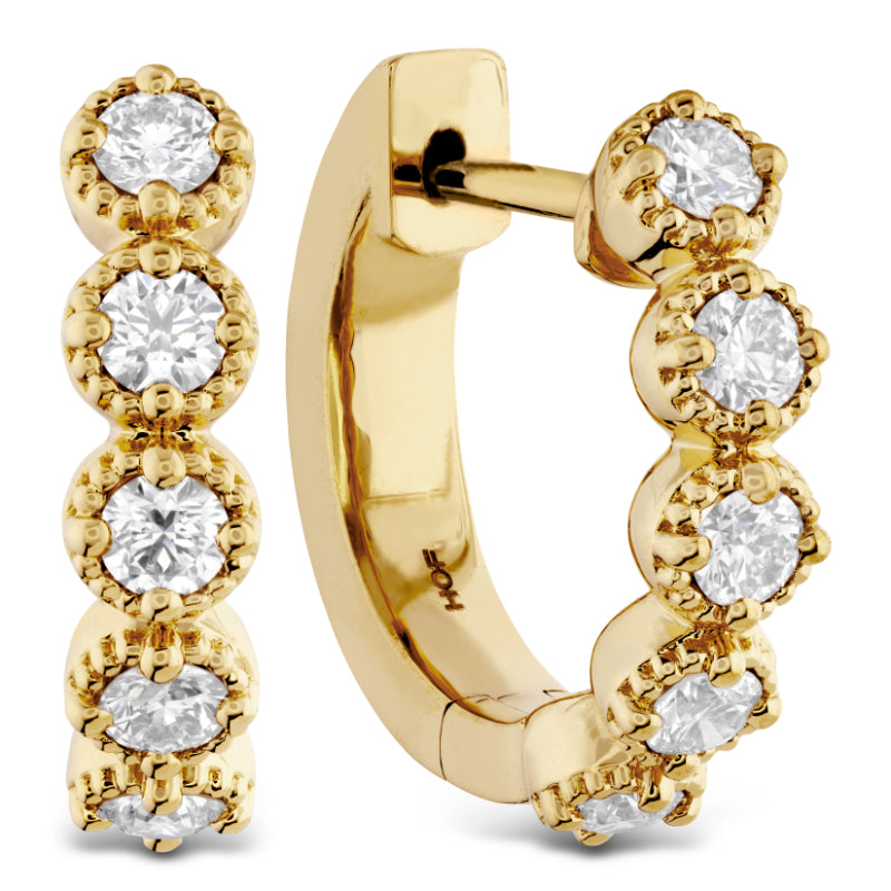 The Hearts On Fire Diamond Bar Huggies feature gold hoop earrings embellished with a row of dazzling round diamonds in a prong setting. Crafted from radiant yellow gold, they exhibit a classic and elegant design that is unmistakably Hearts on Fire.