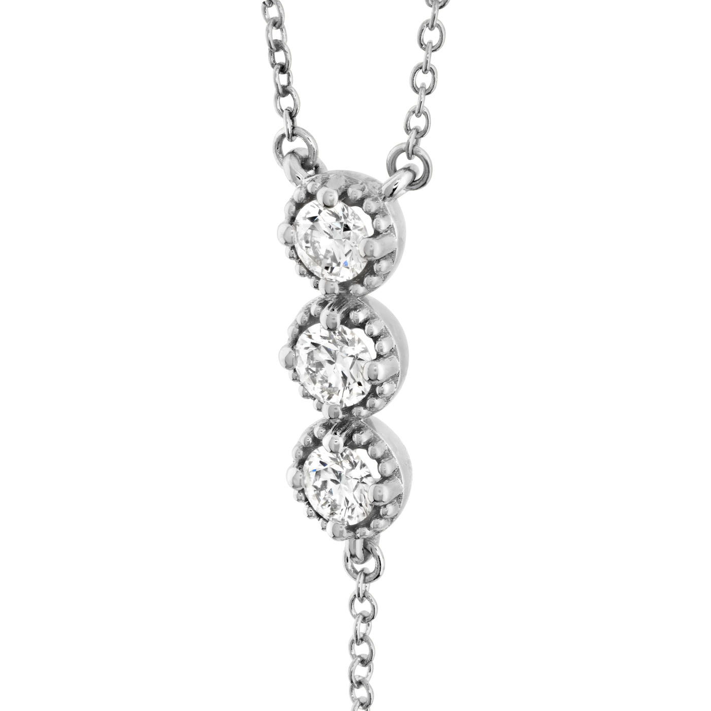 The Hearts On Fire Liliana 18K Gold and Platinum Pendant features a design with three round diamonds set vertically in a silver prong setting, all suspended from a delicate silver chain.