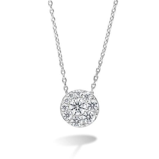 The Hearts On Fire Tessa 18K White Gold Pendant by Hearts on Fire is a breathtaking piece featuring a circular design adorned with numerous small, sparkling diamonds arranged in a starburst pattern, which gracefully hangs from a delicate silver chain.