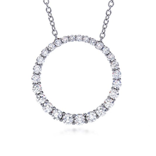 This Hearts on Fire Whimsical 18K White Gold Pendant is displayed on a silver chain, featuring a circle made entirely of sparkling round diamonds. The pendant elegantly connects to the chain, offering a minimalist yet luxurious design.