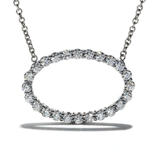 A Hearts On Fire Whimsical 18K White Gold Pendant, featuring an oval design of impeccably arranged diamonds, gleams brilliantly. Suspended by a delicate chain, this luxurious piece showcases elegance and brilliance against its backdrop.