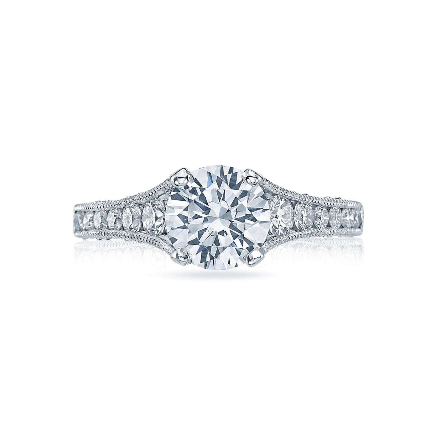 The Tacori Reverse Crescent engagement ring in 18K white gold features a prominent round brilliant diamond solitaire at its center, accented by smaller channel-set diamonds on the intricately detailed band. The elegant design is further enhanced by Tacori's signature crescent silhouettes.