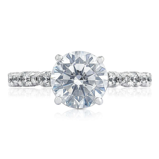 This exquisite Tacori Petite Crescent RoyalT Marquise Shape Design Detail Round Brilliant Diamond Anniversary Ring, crafted by TACORI gemologists, boasts a striking round diamond at its center, surrounded by smaller diamonds elegantly placed along the band. Set against a white background, it highlights the brilliance and intricate craftsmanship of the design.