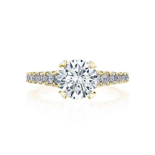 The Tacori Petite Crescent 18K Yellow Gold Round Brilliant Solitaire Semi Mount with Diamond Band Engagement Ring is showcased. The ring features a large round centerpiece, complemented by a diamond-encrusted band that enhances its elegant and luxurious appearance. Displayed against a white background, the ring's sparkling features are truly highlighted.