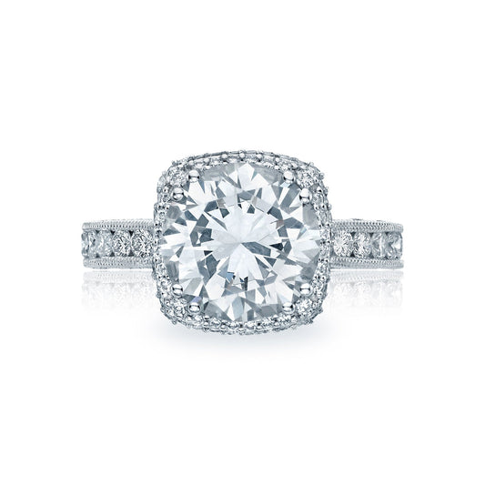 The Tacori Classic Crescent RoyalT Platinum Round Brilliant Semi Mount with Diamond Band and Halo Engagement Ring showcases a large round diamond at its center, surrounded by a halo of smaller diamonds. The platinum band sparkles with its adornment of tiny diamonds, offering an elegant and dazzling appearance.