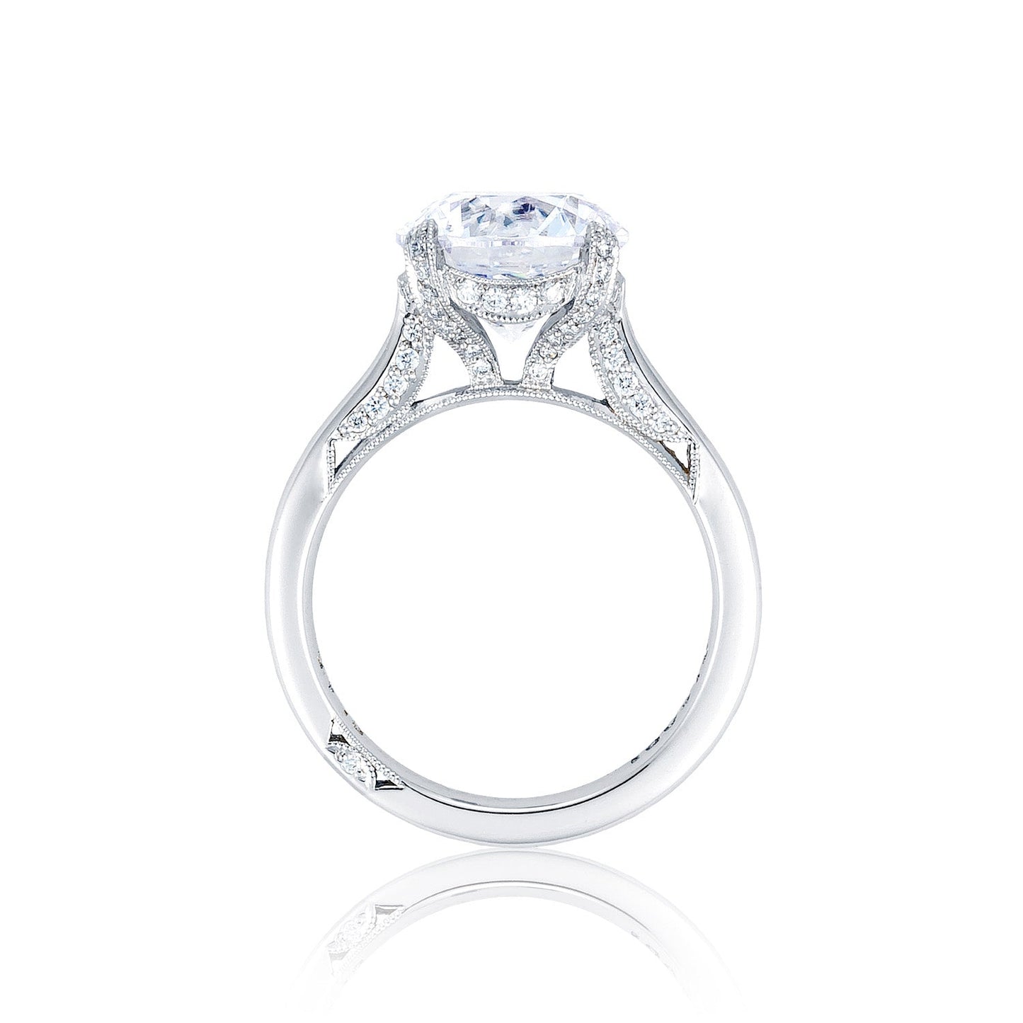 The Tacori Simply Tacori RoyalT Platinum Round Brilliant Solitaire Semi Mount Engagement Ring features an elaborate design with a prominent round diamond centerpiece, complemented by smaller diamonds adorning the band. Expertly crafted by TACORI gemologists, it is showcased against a white background.