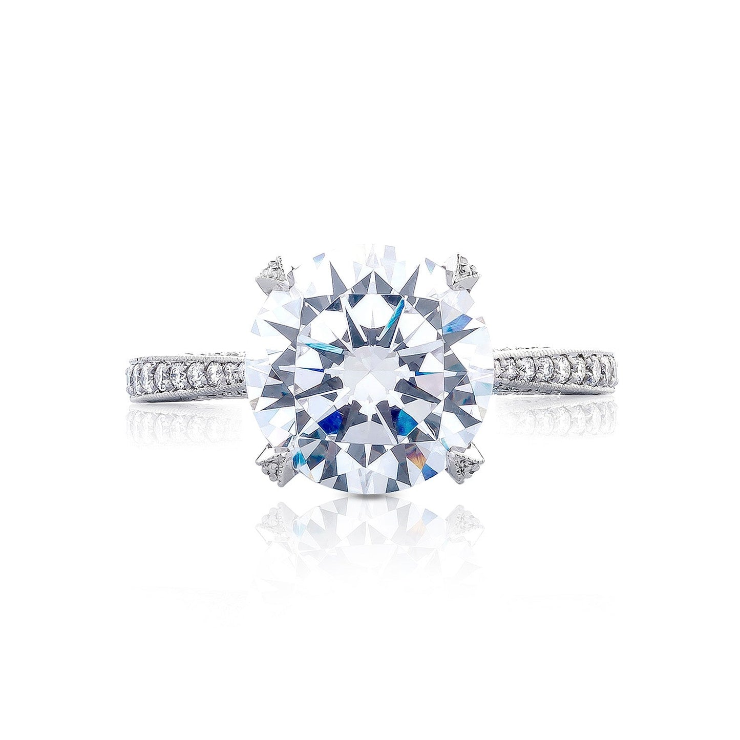 The Tacori Simply Tacori RoyalT engagement ring showcases a breathtaking round brilliant solitaire diamond set on a platinum band, accentuated by smaller diamonds. Its central placement emphasizes the intricate details, capturing the timeless elegance of diamonds.