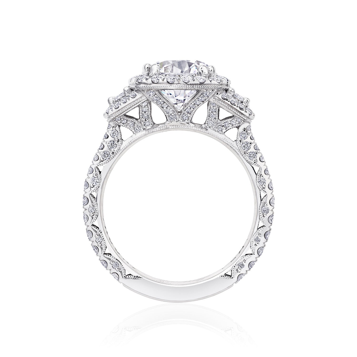 A side view of the Tacori Petite Crescent Royal T Platinum Round Brilliant Three Stone Halo Semi Mount with Diamond Side Stone Engagement Ring reveals a breathtaking central diamond, elegantly bordered by smaller diamonds in a detailed design along the band. Crafted with precision, this exquisite piece exemplifies the artistry of Tacori gemologists.
