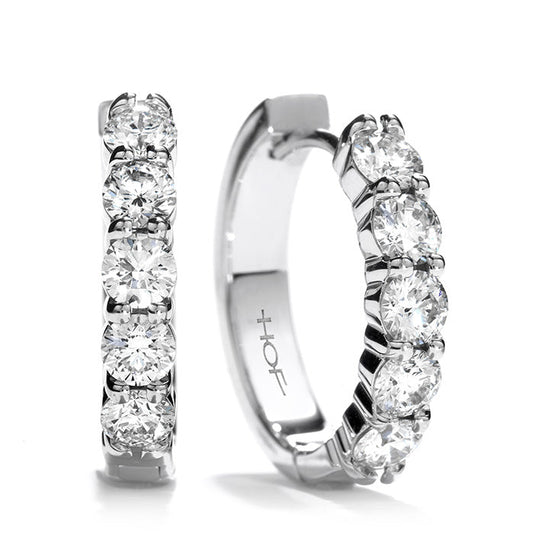 These sophisticated Hearts On Fire Small Mini Hoop Earrings are adorned with dazzling round diamonds and crafted from lustrous white gold. The image displays both the front and side views of the earrings on a simple white background.