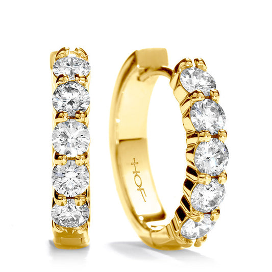Close-up of Hearts On Fire Small Mini Hoop Earrings by Hearts on Fire, crafted from elegant 18 Karat yellow gold and adorned with five sparkling round diamonds each. They feature a smooth, polished finish that exudes a luxurious and sophisticated look.