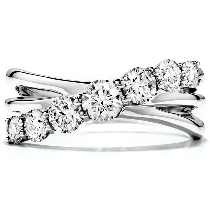 The Hearts On Fire 18K White Gold Round Brilliant Diamond Intermingle Fashion Ring, from the renowned brand Hearts on Fire, boasts an exquisite design with seven round diamonds that increase in size from left to right. The elegant intermingled setting highlights the largest central diamond, serving as a captivating focal point in this stunning arrangement.