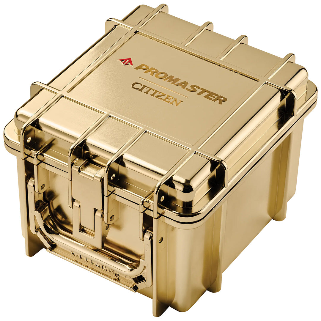 A gold, hard-shell case labeled “CITIZEN PROMASTER,” with a sturdy latch and handle, designed for secure storage or transport of your CITIZEN Promaster Skyhawk A-T Eco-Drive 46mm Watch Limited Edition of 5,200 Pieces or other compatible models featuring advanced atomic timekeeping.