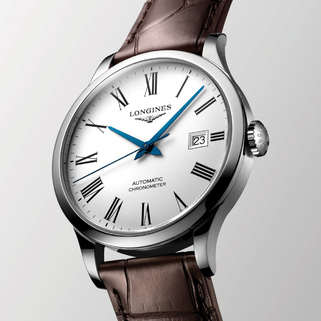 This Longines Record Automatic 40mm Watch epitomizes classic elegance with its silver finish. It features a white dial adorned with Roman numerals and blue hands, and the date is conveniently displayed at 3 o'clock. Detailing "Longines Automatic Chronometer" on the face, this timepiece pairs superbly with its brown leather strap.