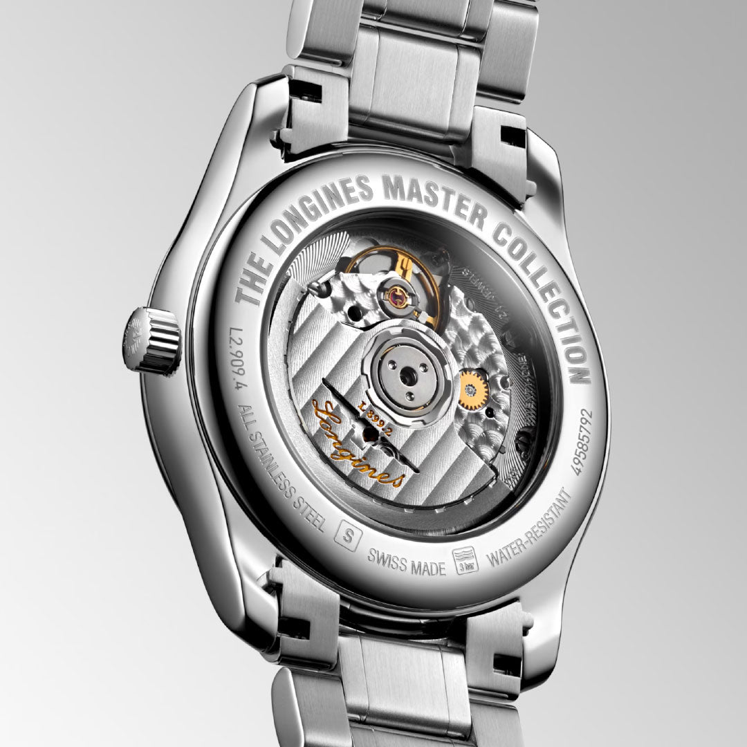Close-up of the Longines Master Collection Moonphase Automatic 40mm watch, revealing fine craftsmanship through its transparent case back, engraved details on the metal edge, and a stainless steel bracelet.