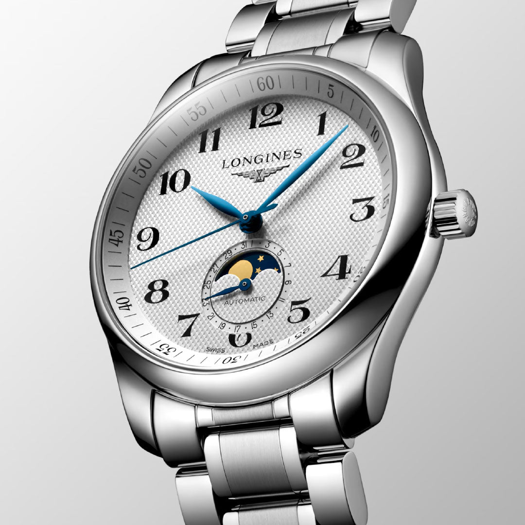 The Longines Master Collection Moonphase Automatic 40mm Watch features a silver stainless steel bracelet, white textured dial, blue hands, Arabic numerals, and a moon phase subdial at 6 o’clock by Longines.
