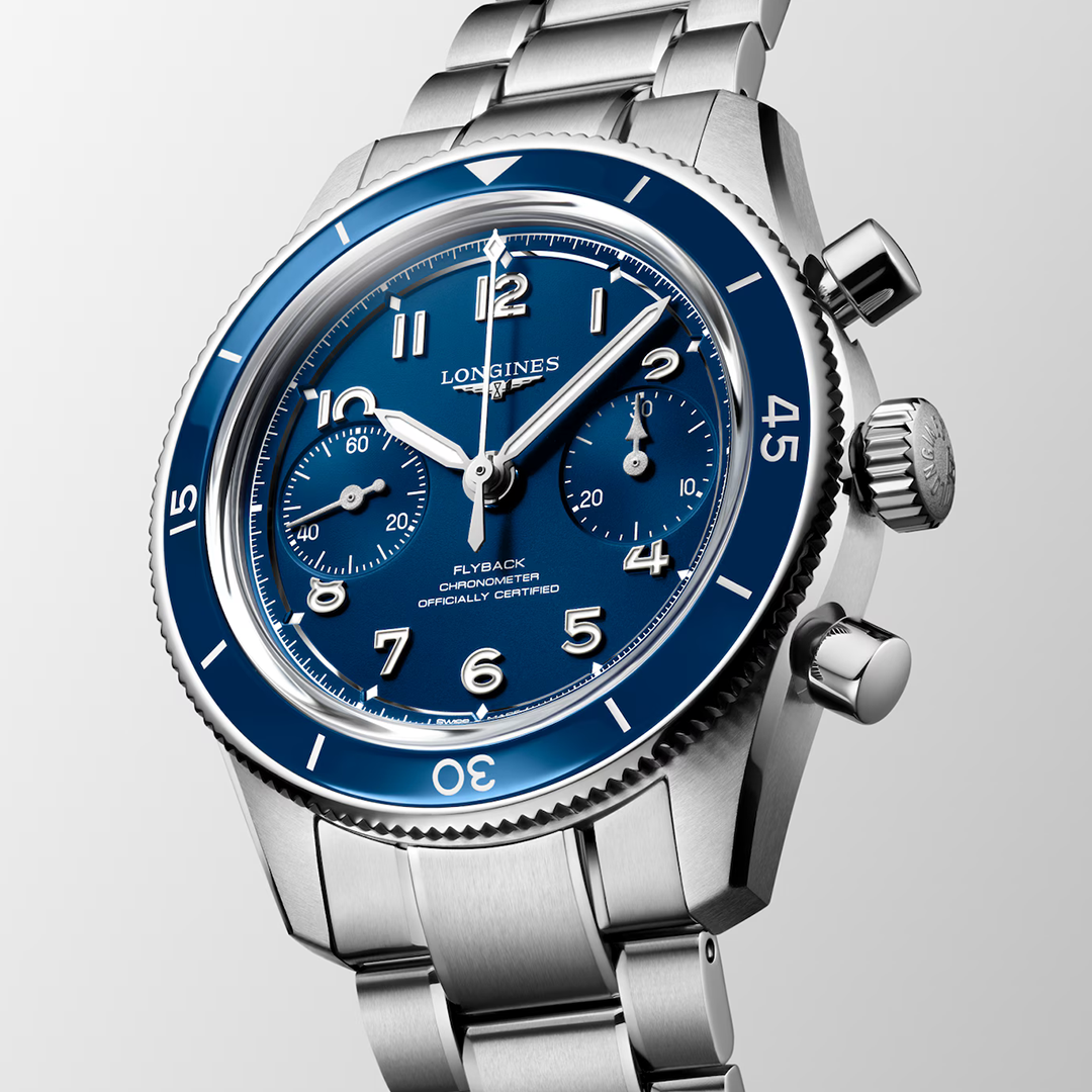 A Longines Spirit Pilot Flyback Automatic Manual Winding 39.5mm Watch featuring a blue dial, stainless steel bracelet, silver-toned markers, and a matching blue rotating bezel.