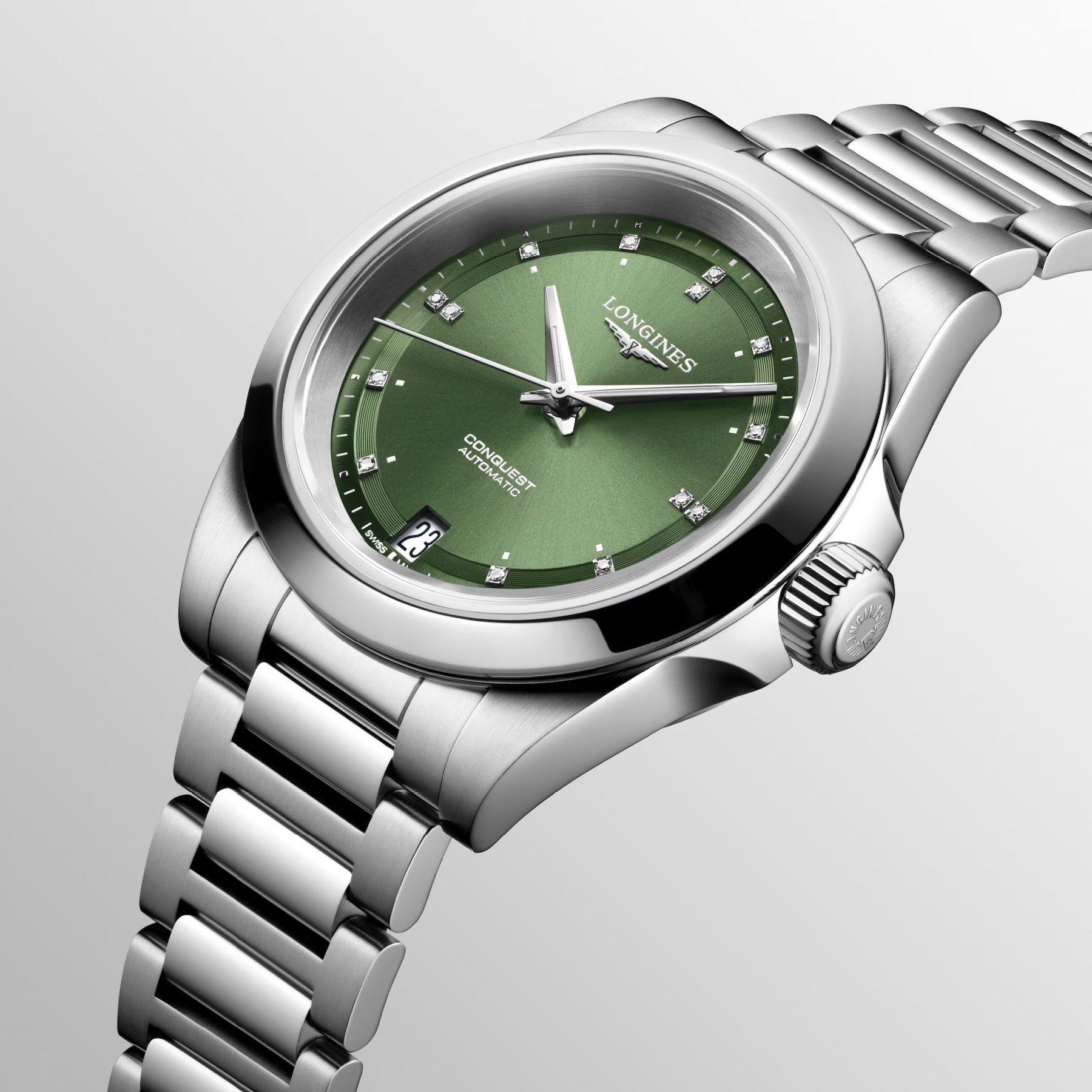 The Longines Conquest Automatic 34mm Watch boasts a silver design with a green dial, elegantly displaying silver hour markers and a date feature at the 6 o'clock position. Its metal bracelet and right-side crown ensure reliable performance. The Longines brand name is discreetly showcased on the dial, capturing an essence of stylish conquest.