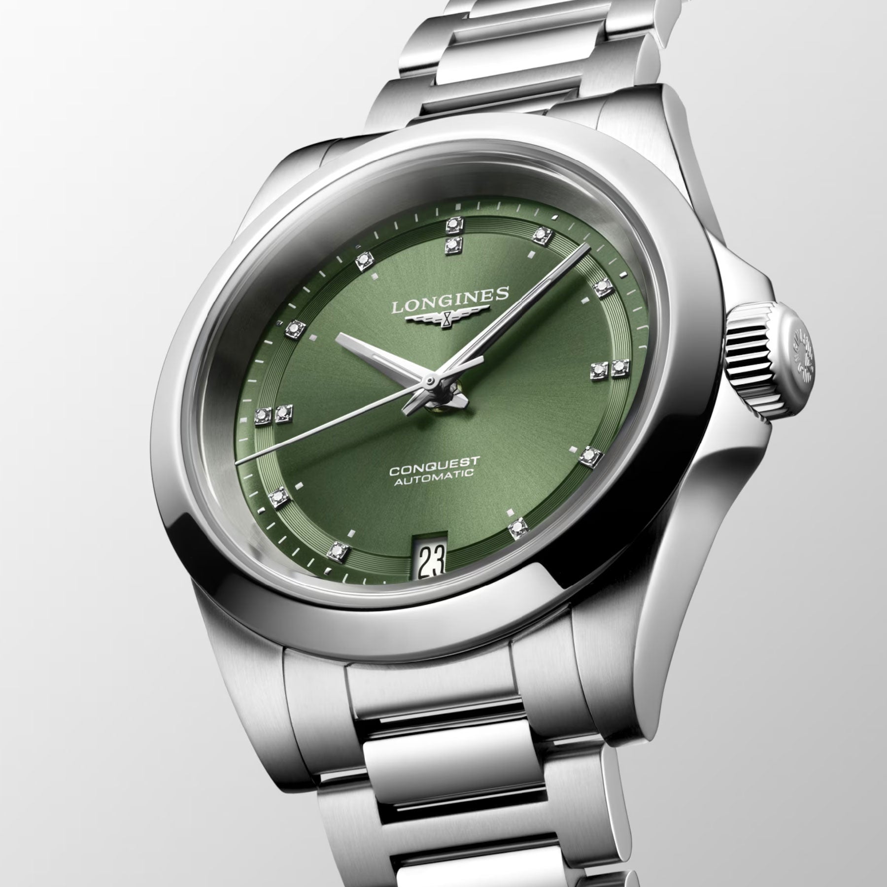 A close-up of the sophisticated Longines Conquest Automatic 34mm watch, featuring a captivating green dial and a silver-tone stainless steel bracelet. This timepiece from Longines is renowned for its outstanding performance, showcasing a date display at 6 o'clock and adorned with diamond hour markers.