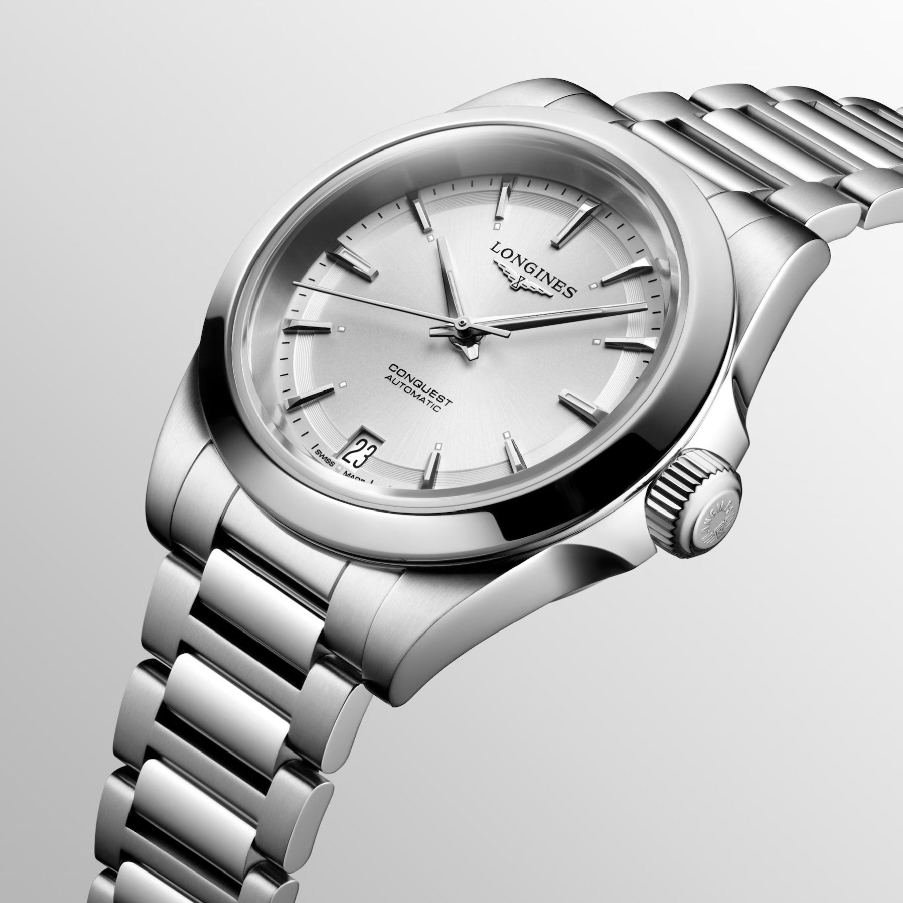 The Longines Conquest Automatic 34mm Watch exudes elegance with its silver metallic strap and sleek bezel. Its minimalistic face showcases silver markers and hands, along with a date display at six o'clock, offering a perfect blend of style and performance. The prestigious Longines brand name is prominently displayed below twelve o'clock.